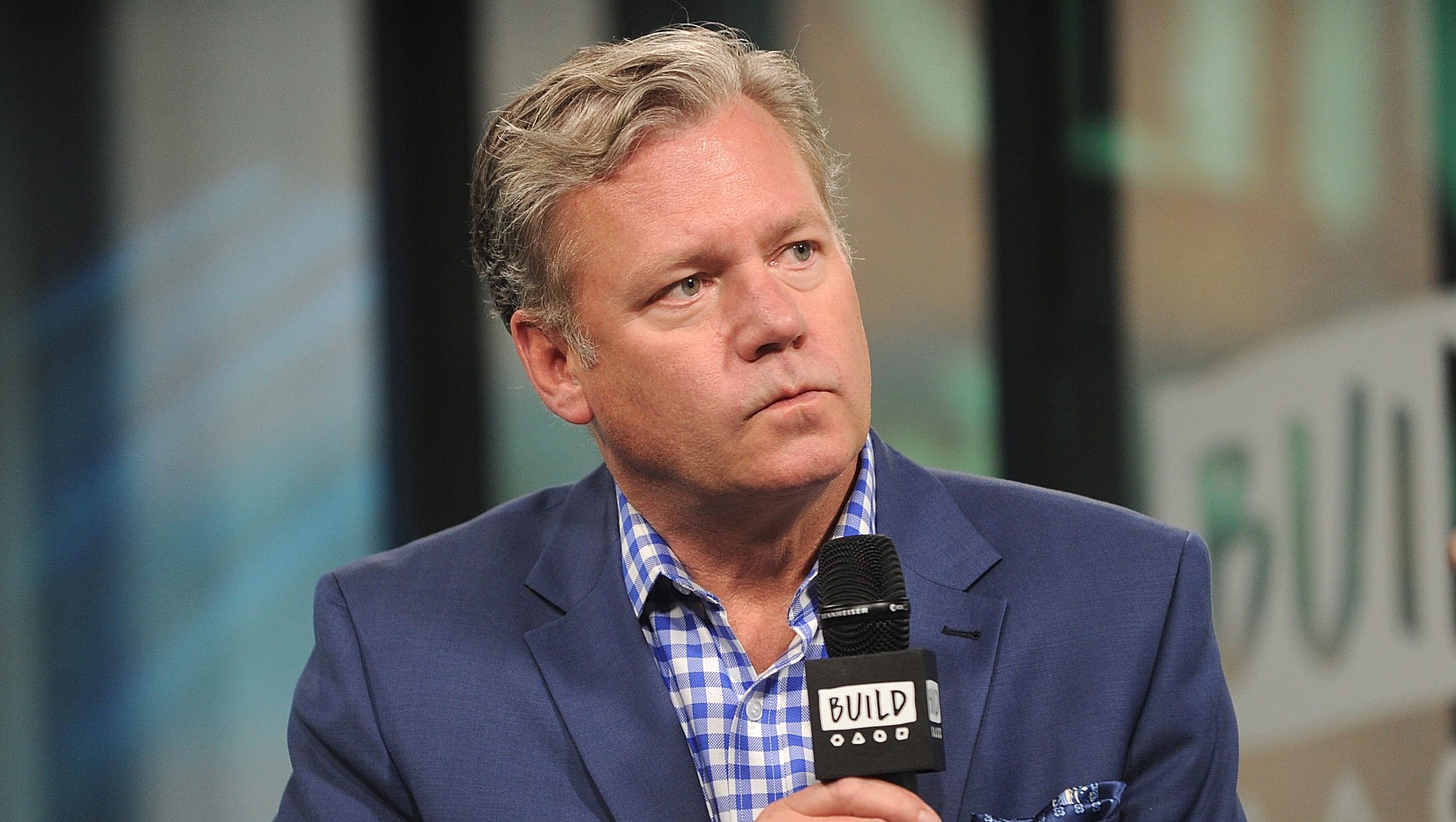 Chris Hansen speaks into a microphone during an interview as the former